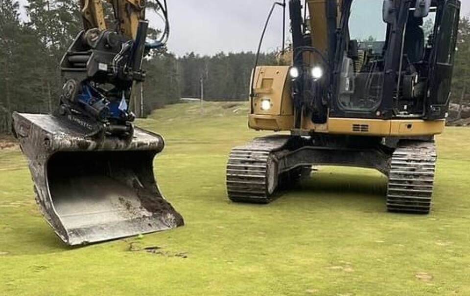 Maskinfører Kjell Arne Belsby putter den siste putten med gravemaskinen på hull 8 på Skjeberg Golfklubb før greenen forsvinner.