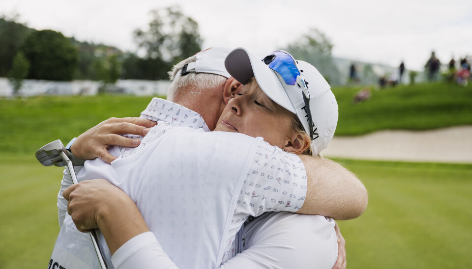 Renate Grimstad får seiersklem av caddie og pappa etter siste putt i årets norgesmesterskap. Dette er hennes første kongepokal.