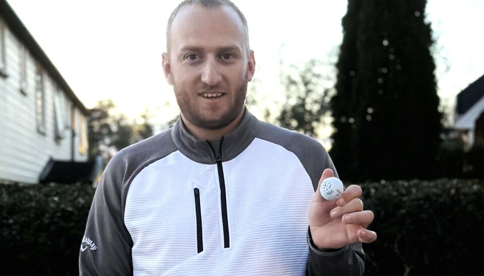 Tim Kristian Lauritzen viser fra golfballen som han sendte 288 meter og rett i koppen via flaggstangen.