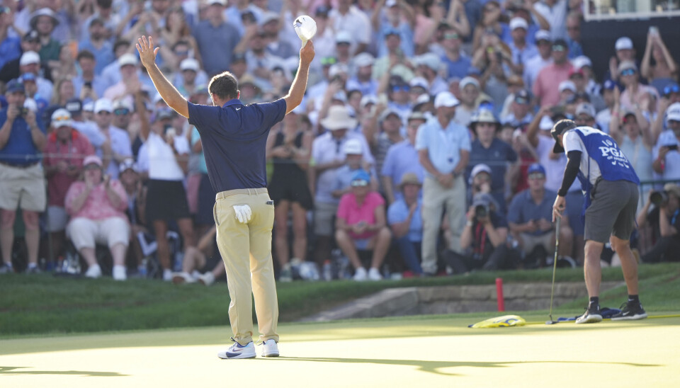 Scottie Scheffler strekker hendene i været etter å ha vunnet årets PGA-mesterskap.