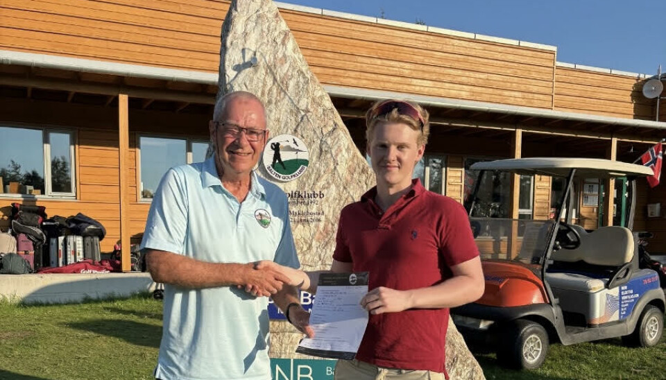 18 år gamle Teodor Bakkejord Alvestad blir overrakt gavekortet som bevist på at han er medlem nummer 1000 av daglig leder Sigve Bollestad i Salten Golfklubb.
